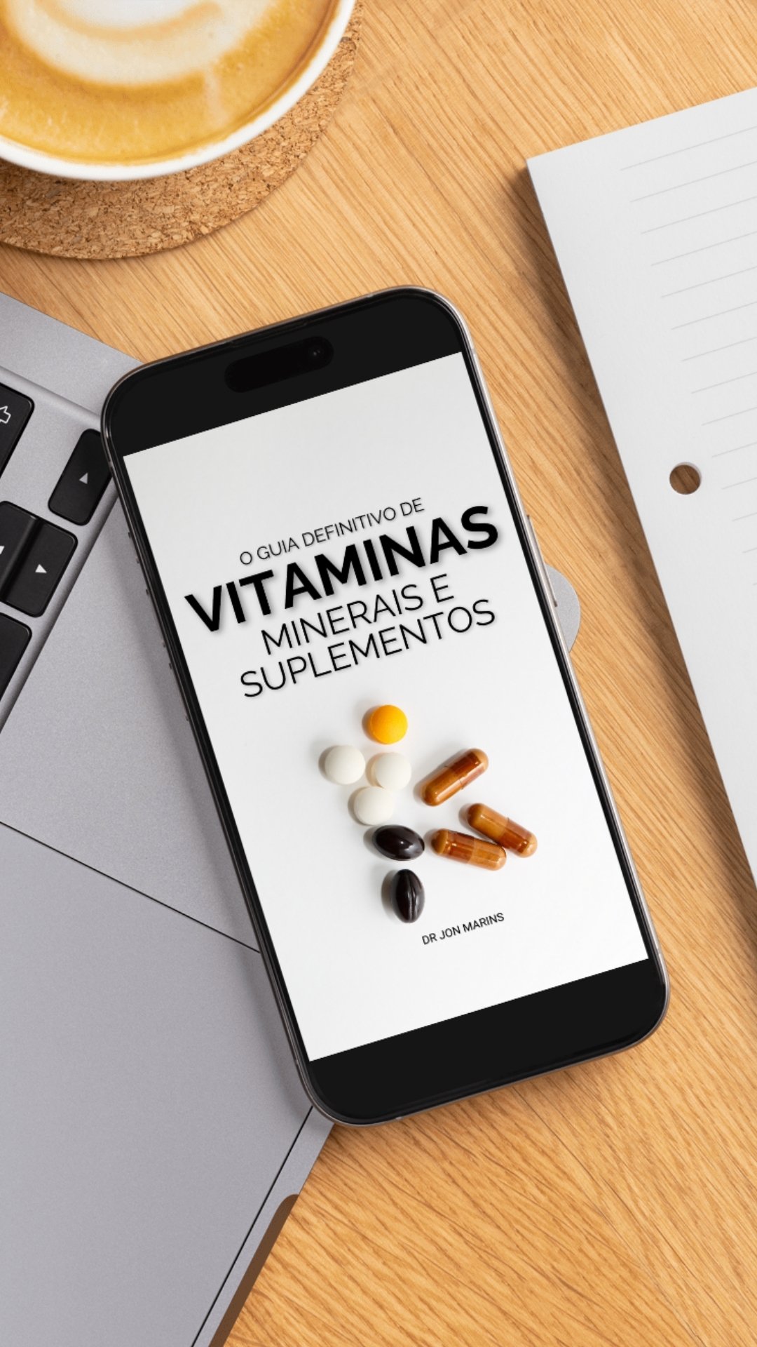 Celular na mesa com guia aberto ao lado do laptop